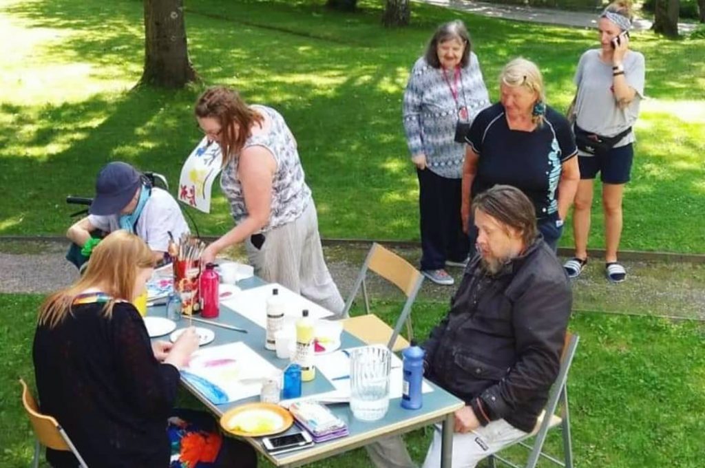 Kesäkahvilassa järjestettiin monipuolista ohjattua toimintaa. Kuvassa maalataan pöydän ääressä.